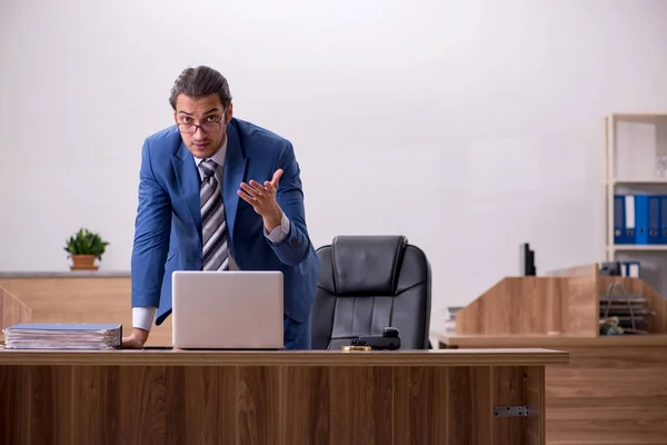 Jovem trabalhador masculino sentado no local de trabalho — Fotografia de Stock