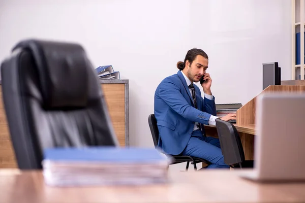 Fiatal férfi alkalmazott ül a munkahelyen — Stock Fotó