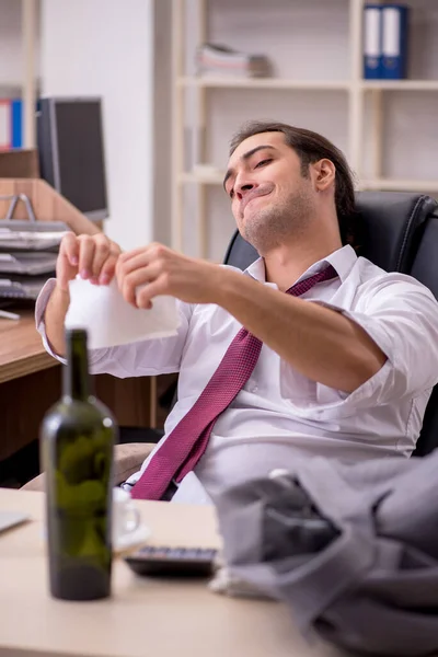 若い男性社員が事務所でアルコールを飲む — ストック写真