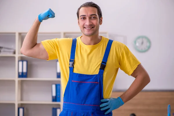 사무실 청소하는 젊은 남자 건설업자 — 스톡 사진