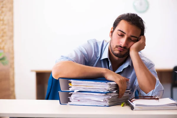 Jovem funcionário masculino infeliz com excesso de trabalho no escritório — Fotografia de Stock