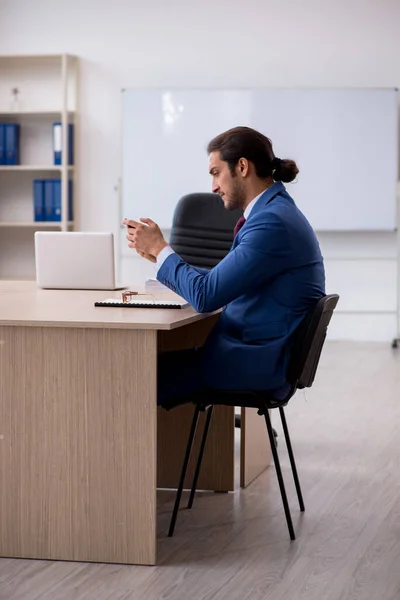 Jeune employé masculin assis dans le bureau devant le tableau blanc — Photo