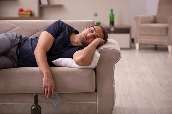 Jovem alcoólico masculino assistindo tv em casa — Fotografia de Stock