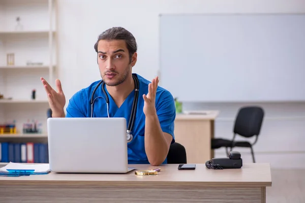 Ung manlig läkare som arbetar på kliniken — Stockfoto