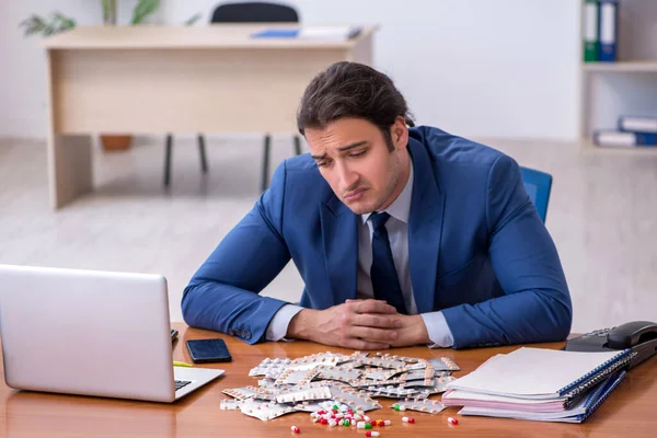 Young male sick employee suffering at workplace — Stock Photo, Image