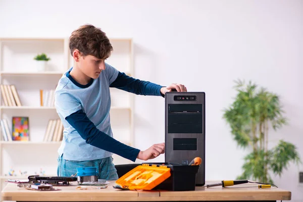 Мальчик чинит компьютеры в мастерской — стоковое фото