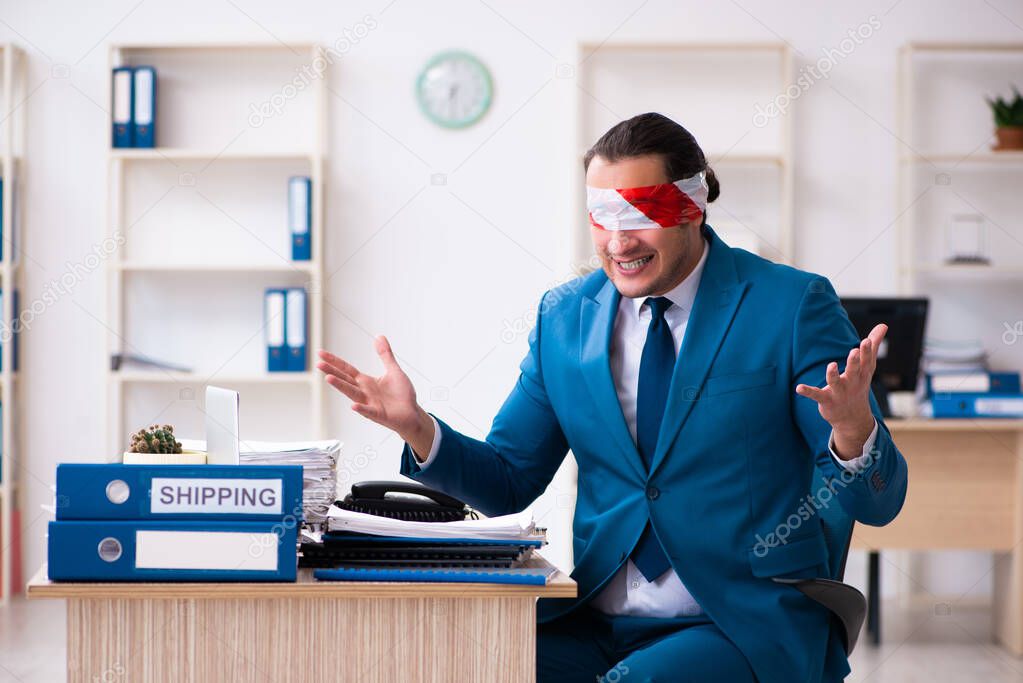 Blindfolded male employee working in the office