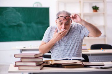 Sınav hazırlıkları sırasında yorgun düşen yaşlı bir erkek öğrenci.