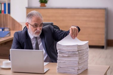 Ofiste çalışan yaşlı bir erkek.