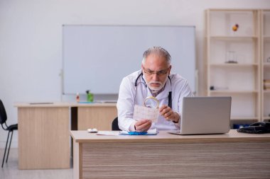 Klinikte çalışan yaşlı bir erkek kardiyolog.