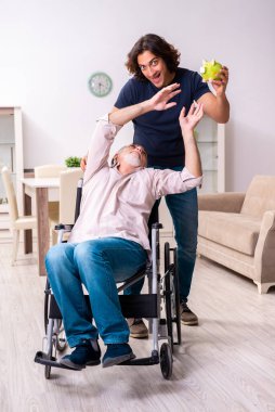 Tekerlekli sandalyedeki yaşlı adam ve genç kötü bakıcı.