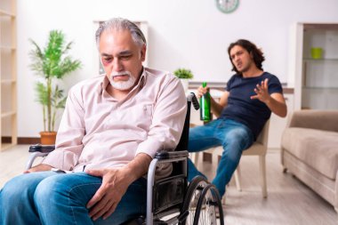 Tekerlekli sandalyedeki yaşlı adam ve genç kötü bakıcı.