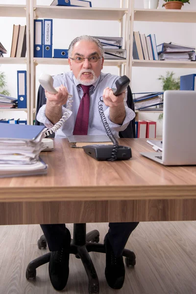 Oude mannelijke werknemer ongelukkig met overmatig werk — Stockfoto