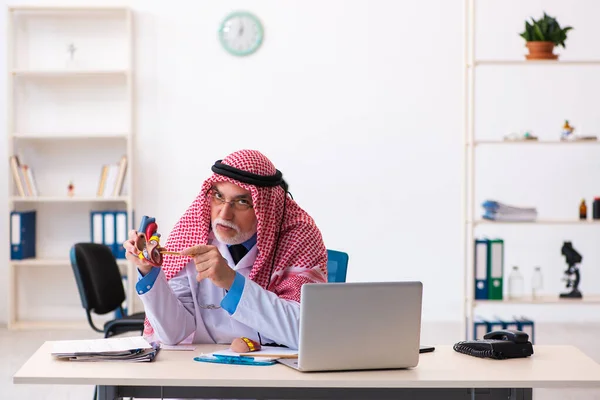 Vecchio medico arabo maschio cardiologo che lavora in clinica — Foto Stock