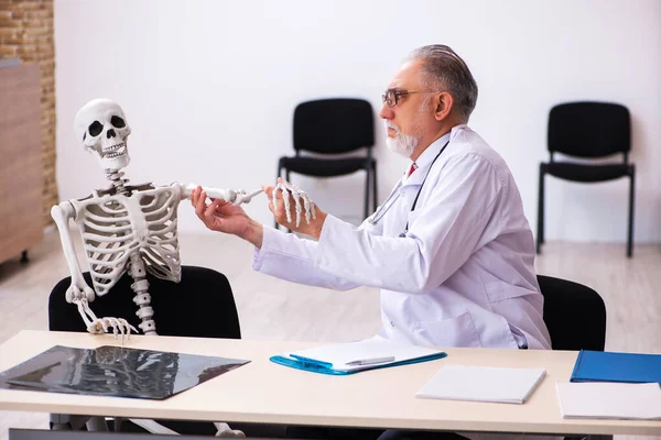 Anciano médico y paciente esqueleto en la clínica —  Fotos de Stock