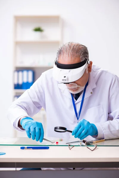 Oude mannelijke expert criminoloog werkt in het lab voor bewijs — Stockfoto