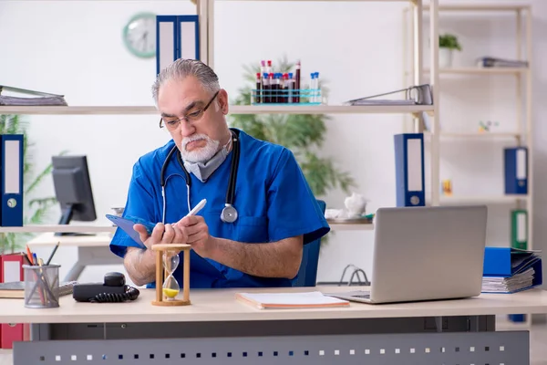 Starý lékař pracující na klinice — Stock fotografie