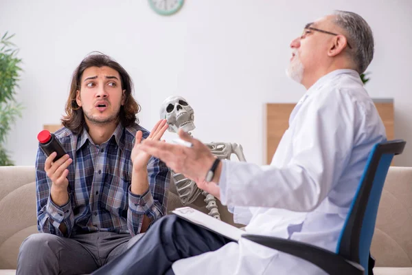 Jovem paciente do sexo masculino visitando médico psiquiatra experiente — Fotografia de Stock
