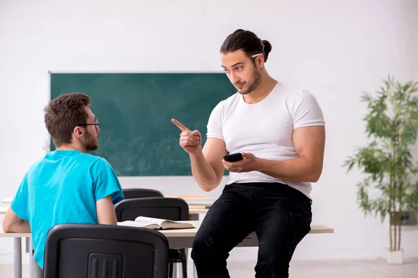 Twee mannelijke leerlingen in het pestconcept in de klas — Stockfoto