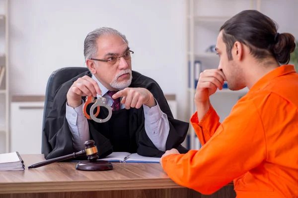 Vecchio giudice uomo incontro con giovane prigioniero in tribunale — Foto Stock