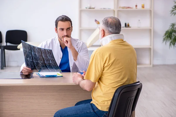 Yaşlı boyun yaralanması genç erkek doktor radyolojisti ziyaret ediyor. — Stok fotoğraf