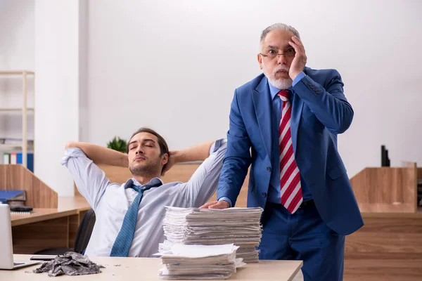 Young male employee and old boss burning papers at workplace — Stock Photo, Image