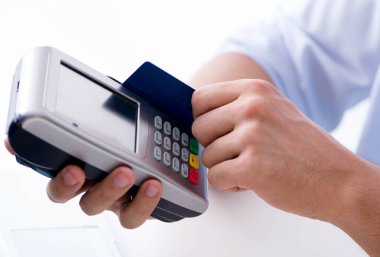 POS terminali ile kredi kartı işlemi yapan adam