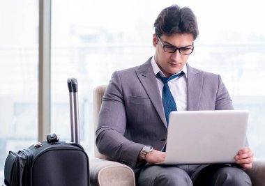 Havaalanındaki iş yerinde genç işadamı uçuş için bekliyor.