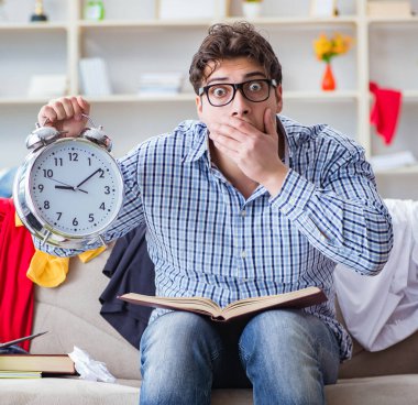 Genç adam dağınık bir odada çalışıyor.