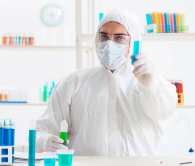 Laboratuvarda kimyasallar üzerinde çalışan genç bir kimyager.