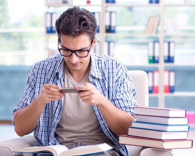 Öğrenci kitap okuyor ve kütüphanede sınavlara hazırlanıyor