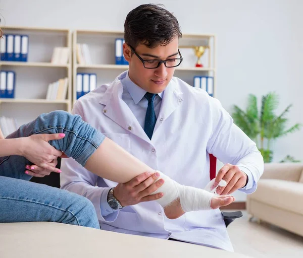 Hastanede yaralanma kontrolü sırasında doktor ve hasta.