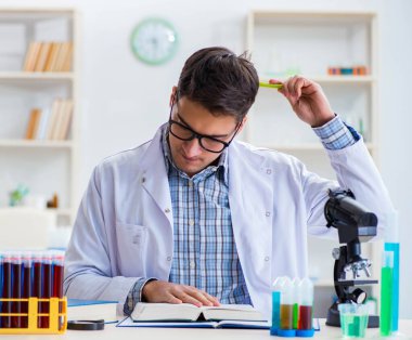 Laboratuvarda kimyasallar üzerinde çalışan genç bir kimyager.