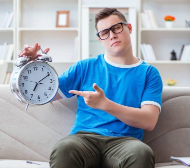 Sınavlara hazırlanan genç öğrenci kanepede ders çalışıyor.