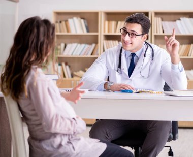 Hamile kadın muayene için doktoru ziyaret ediyor.