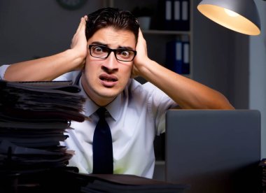 Genç işadamı geç saatlere kadar ofiste çalışıyor.