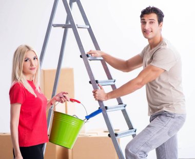 Ev tadilatı sırasında genç bir aile boya işi yapıyor.