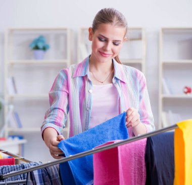 Genç ev hanımı evde çamaşır yıkıyor.