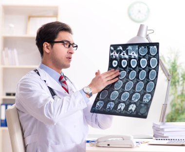 Hastane odasında çalışan yakışıklı genç bir doktor.