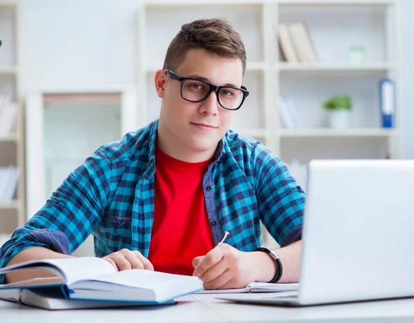 Jong tiener voorbereiding voor examens studeren aan een bureau binnen — Stockfoto