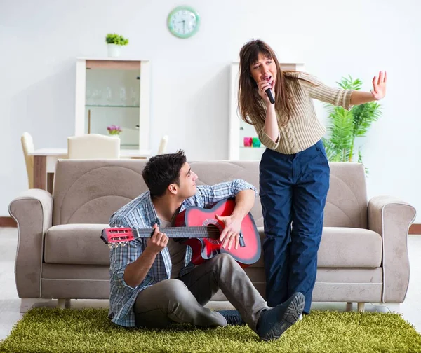 Ung familj sjunger och spelar musik hemma — Stockfoto