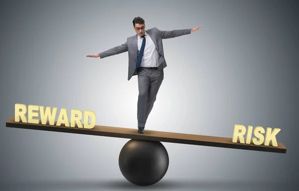 Businessman balancing between reward and risk business concept — Stock Photo, Image