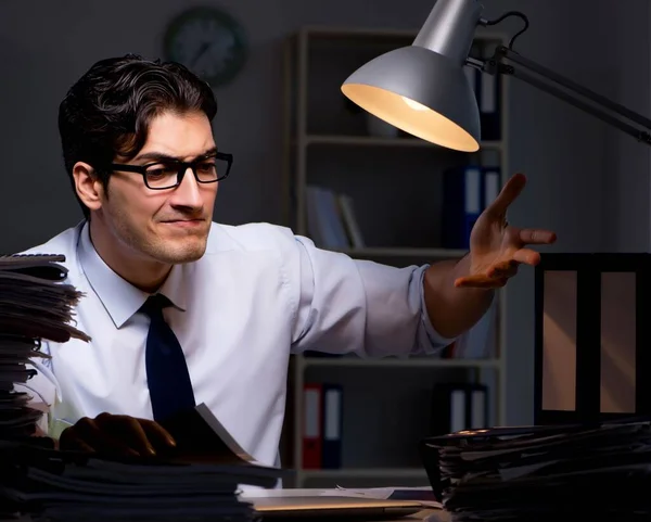 Joven hombre de negocios trabajando horas extras hasta tarde en el cargo — Foto de Stock