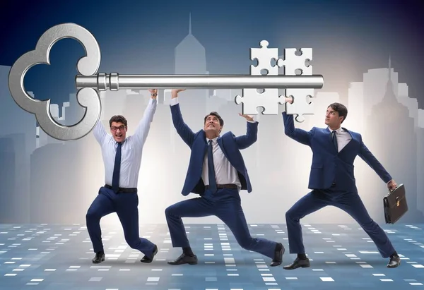 Empresários segurando chave gigante no conceito de negócio — Fotografia de Stock