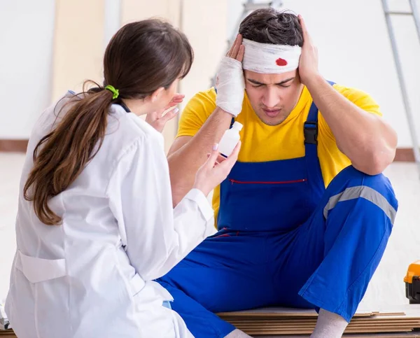 Lavoratore con testa ferita e medico — Foto Stock