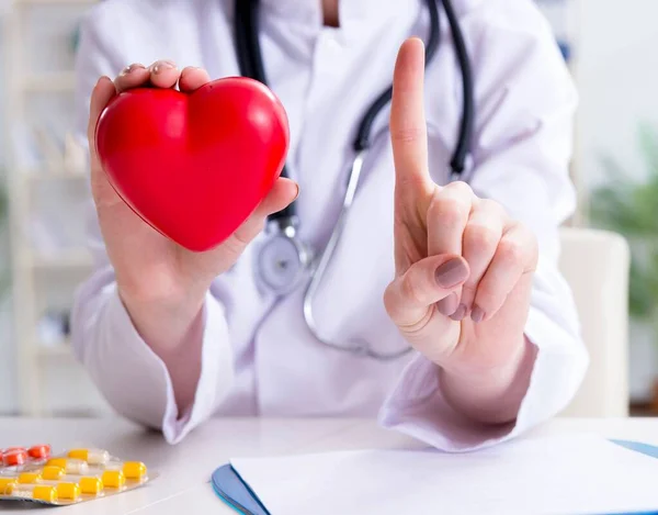 Medico cardiologo con cuore rosso in ospedale — Foto Stock