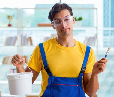 Atölyede bir kova boyalı ressam.