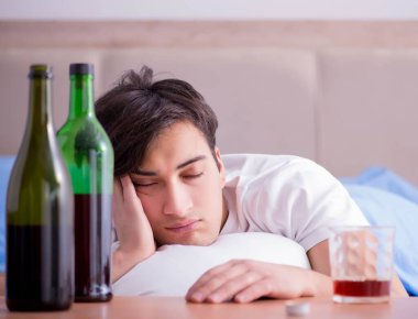 Yatakta içen alkolik adam depresyona giriyor.
