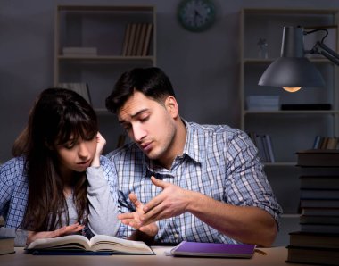 İki öğrenci gece geç saatlere kadar çalışıyor.