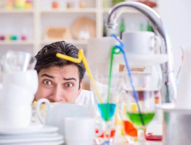 Bulaşıkları yıkamaktan bıkmış bir adam.